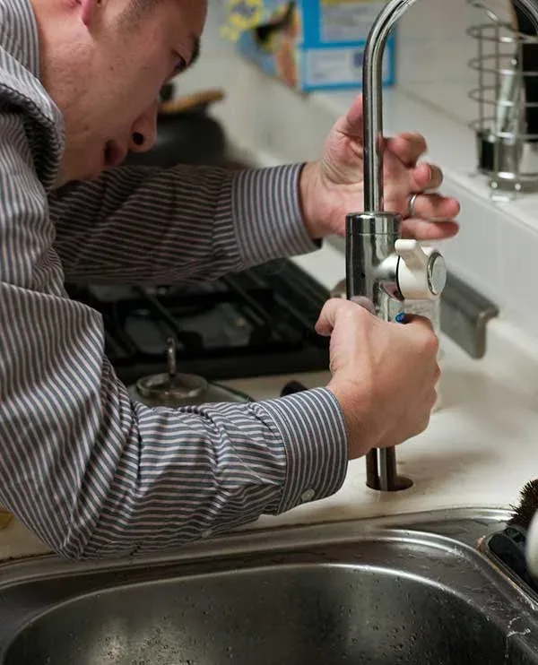 Plumber installing a kitchen faucet